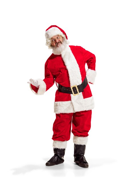 Hey hallo. Holly Jolly X Mas festlichen Noel. Volle Länge des lustigen glücklichen Weihnachtsmanns in der Kopfbedeckung, im Kostüm, im schwarzen Gürtel, in den weißen Handschuhen, Wellen mit Armpalme, die im Studio über weißem Hintergrund stehen