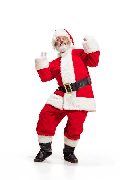 Hey hallo. Holly Jolly X Mas festlichen Noel. Volle Länge des lustigen glücklichen Weihnachtsmanns in der Kopfbedeckung, im Kostüm, im schwarzen Gürtel, in den weißen Handschuhen, Wellen mit Armpalme, die im Studio über weißem Hintergrund stehen