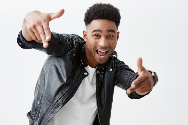 Hey Mann. Positive Gefühle. Junger gut aussehender schwarzhäutiger Mann mit Afro-Frisur in Freizeitkleidung, die mit der Hand in der Kamera mit aufgeregtem Gesichtsausdruck zeigt und für Foto auf Partei aufwirft.