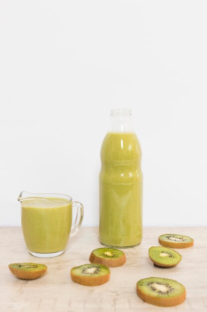 High Angle Kiwi Smoothie in Flasche und Tasse