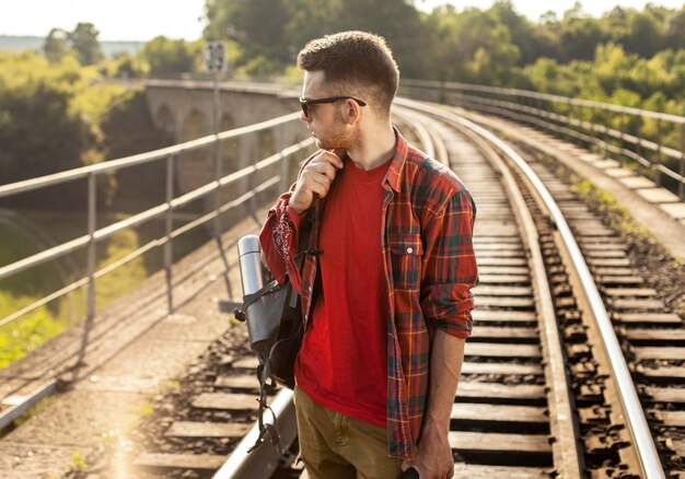 High Angle Man mit Rucksack auf Zugschiene