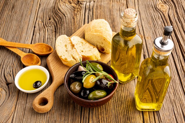 High Angle Oliven mischen Brot und Ölflaschen