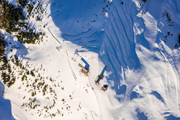 High Angle Shot der fantastischen Winterlandschaft der schneebedeckten Berge während eines sonnigen kalten Tages