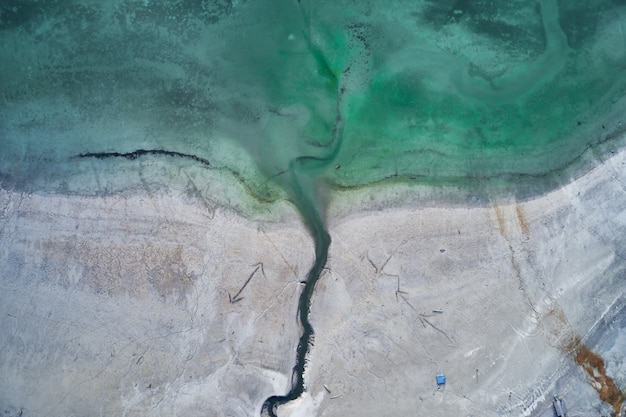 Kostenloses Foto high angle shot des türkisfarbenen wassers des meeres neben dem ufer mit gravuren von pfeilen