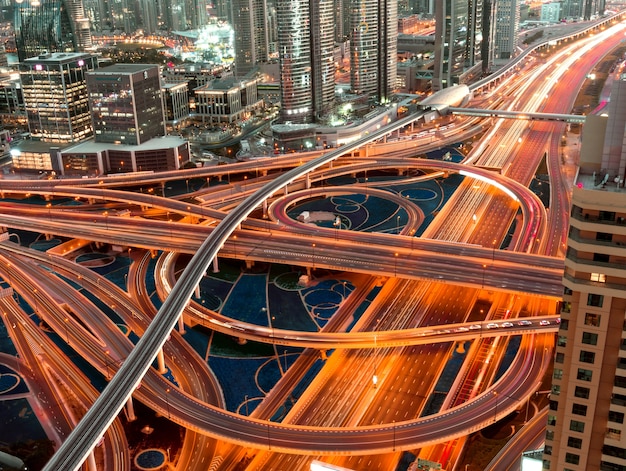 High Angle Shot einer beleuchteten Autobahn mit mehrstufigen Kreuzungen in einer Megapolis bei Nacht