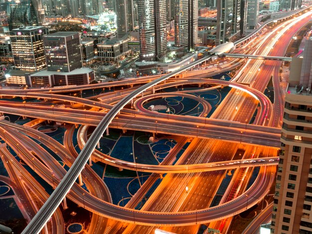 High Angle Shot einer beleuchteten Autobahn mit mehrstufigen Kreuzungen in einer Megapolis bei Nacht
