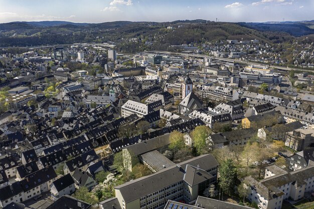 High Angle Shot einer schönen Stadt, umgeben von Hügeln unter dem blauen Himmel