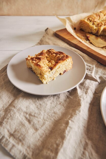 High Angle Shot von einem Stück köstlichen Jerry Crumble Sheet Cake auf einem weißen Holztisch