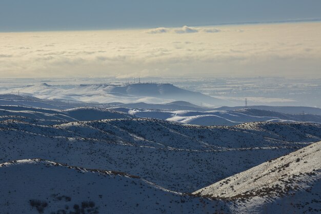 High Angle Shot von schneebedeckten Bergen mit einem blauen bewölkten Himmel am Tag