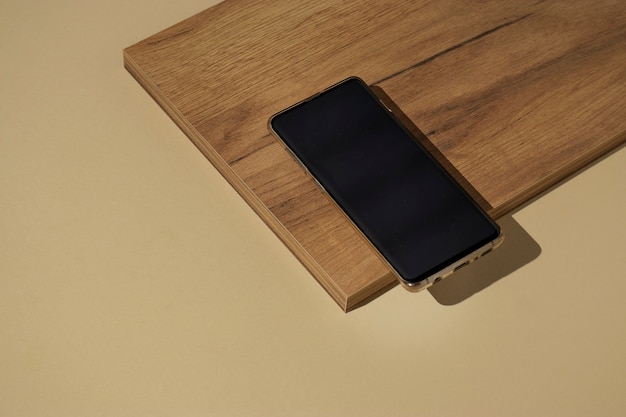 High Angle Smartphone auf Holzbrett