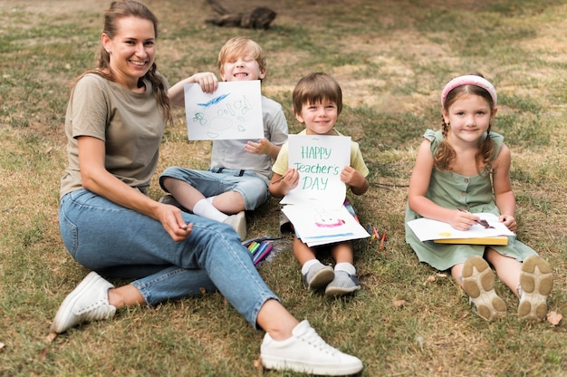 High angle smiley lehrer und kinder im freien