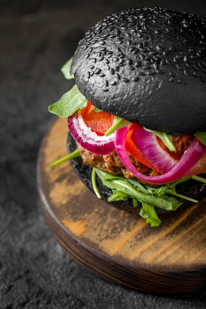Kostenloses Foto high angle veggie burger mit schwarzen brötchen auf schneidebrett