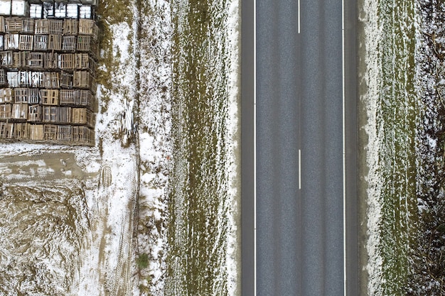 High Angle View einer Straße, umgeben von einer mit Schnee bedeckten Wiese mit metallischen Gegenständen