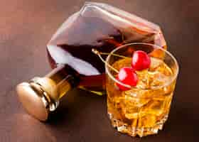 Kostenloses Foto high angle whisky glas und kirschen mit flasche