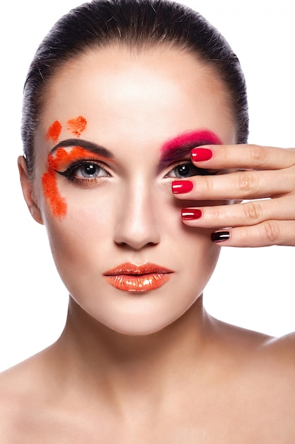 High Fashion Look.Glamour Nahaufnahme Porträt der schönen sexy Brünette junge Frau Modell mit orange Lippen und perfekte saubere Haut mit bunten Nägeln