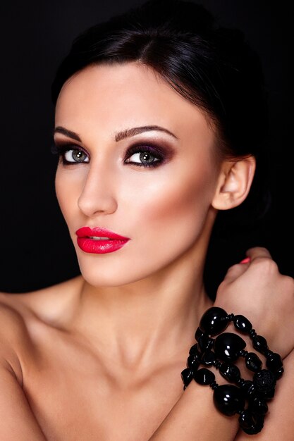 High Fashion Look.Glamour Nahaufnahme Porträt des schönen sexy kaukasischen jungen Frau Modell mit roten Lippen, hellem Make-up, mit perfekter sauberer Haut lokalisiert auf Schwarz