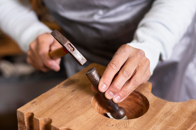 High View Handwerker hämmert ein Stück Metall