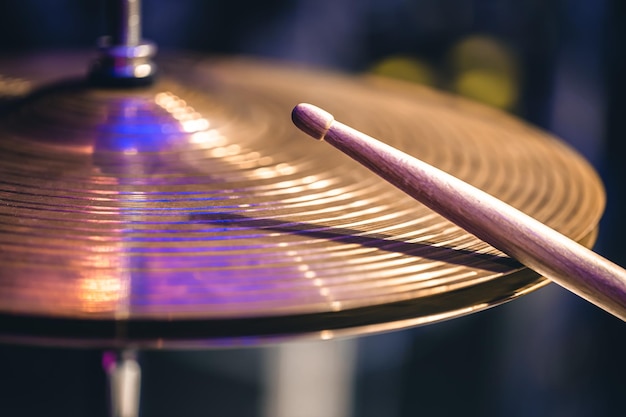 Kostenloses Foto hihat-nahaufnahme von tellern mit drumsticks auf einem hintergrund aus farbigen laternen