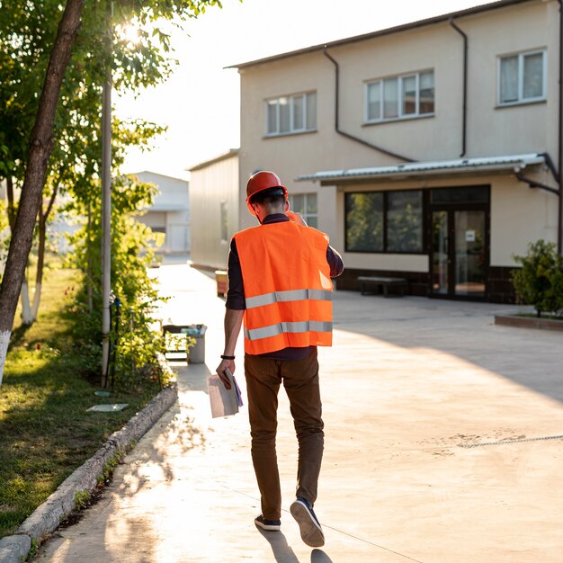 Hintere Ansicht der Arbeitskraft mit Schutzausrüstung