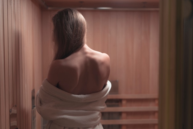 Hintere Ansicht der rückenlosen sexy jungen Frau in der Sauna