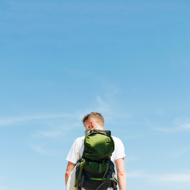 Kostenloses Foto hintere ansicht des jungen mannes stehend gegen blauen himmel