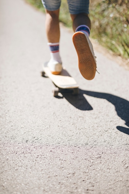 Hintere Ansicht des Kerls Skateboard fahrend