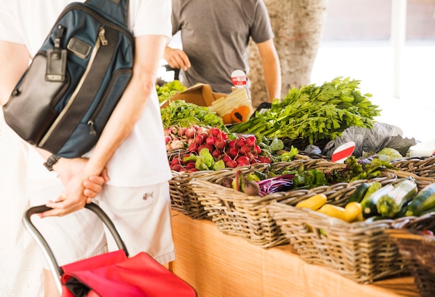 Kostenloses Foto hintere ansicht des mannes organisches gemüse am markt kaufend