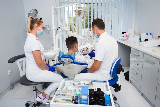 Kostenloses Foto hintere ansicht des patienten und des zahnarztes im büro