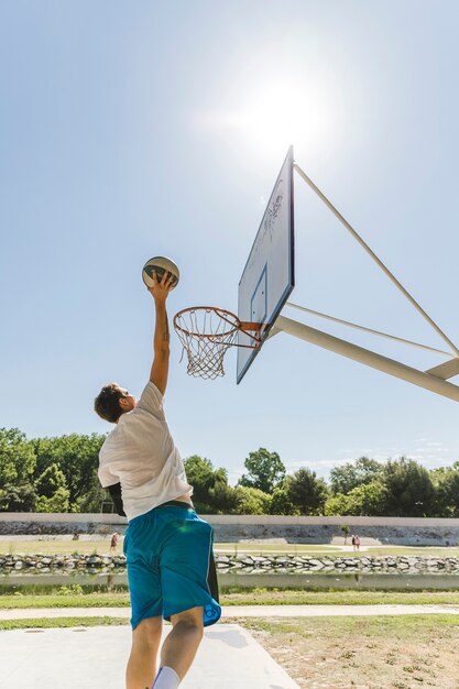 Hintere Ansicht des werfenden Balls des Basketball-Spielers im Band