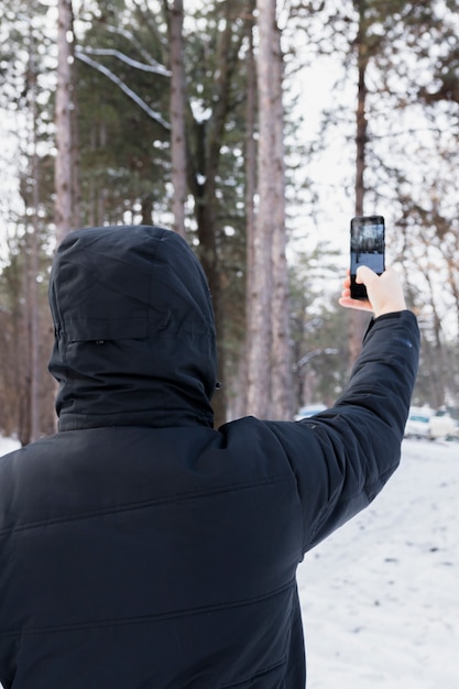 Hintere Ansicht einer Frau, die Foto im Handy macht