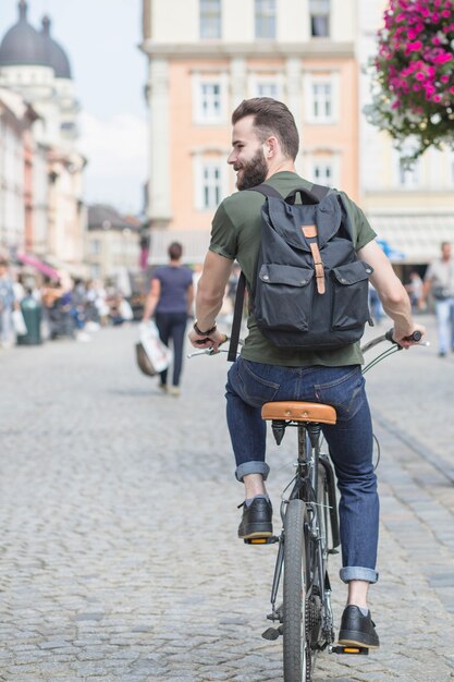 Hintere Ansicht eines Fahrrades des jungen Mannes Reit in der Stadt