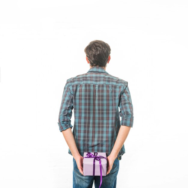 Hintere Ansicht eines Mannes mit der Geschenkbox, die auf weißem Hintergrund steht