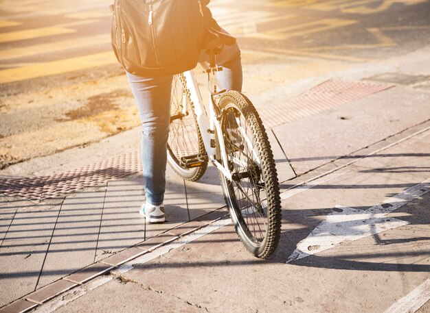 Hintere Ansicht eines Radfahrers mit dem Rucksack, der auf Straße wartet