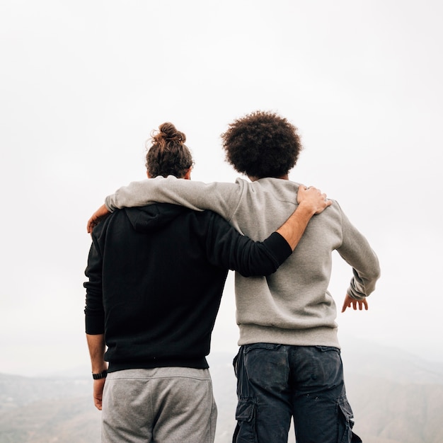 Kostenloses Foto hintere ansicht von den multi ethnischen jungen männlichen wanderern, die ansicht übersehen