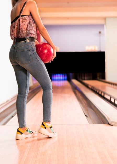 Hintere Ansichtfrau, die Bowlingkugel hält