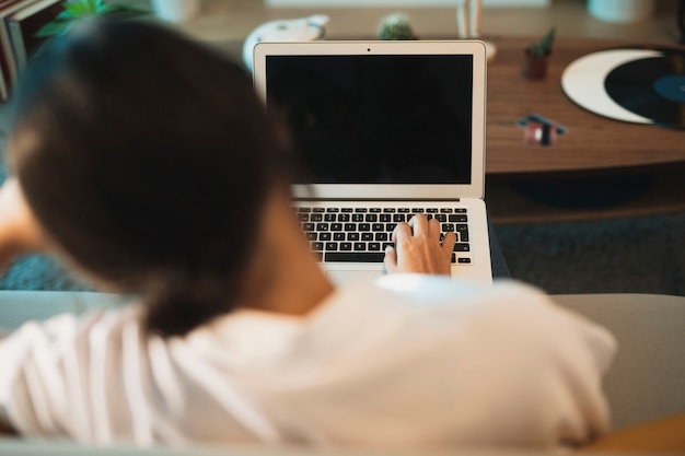 Kostenloses Foto hintere ansichtfrau, die oben an laptopspott arbeitet