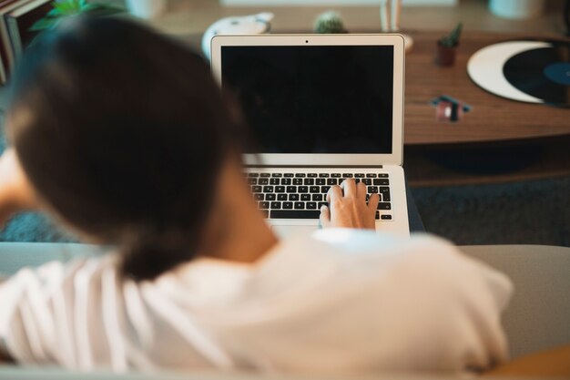 Hintere Ansichtfrau, die oben an Laptopspott arbeitet