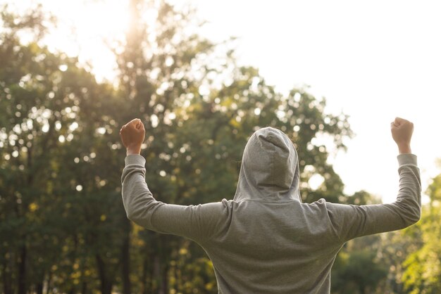 Hintere Ansichtfrau mit Hoodie draußen