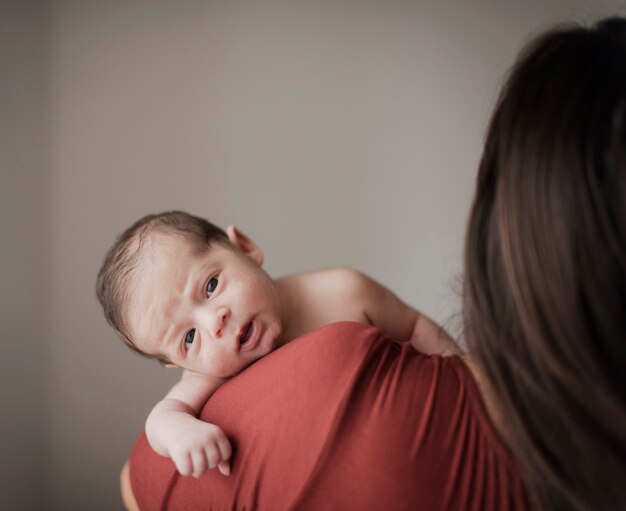 Hintere Ansichtmutter, die kleines Baby hält