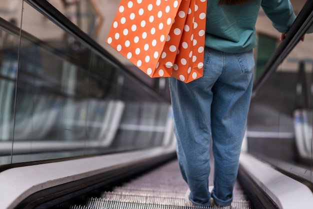 Kostenloses Foto hintere ansichtperson, die rolltreppe hinuntergeht