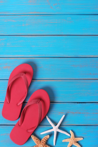 Hintergrund der blauen hölzernen Hintergrundvertikale der Flipflops-Starfishsommerküste