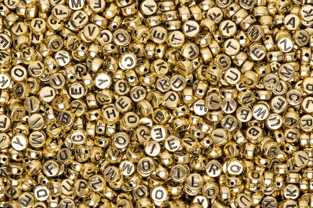 Hintergrund des englischen Alphabets der metallischen Goldperlen