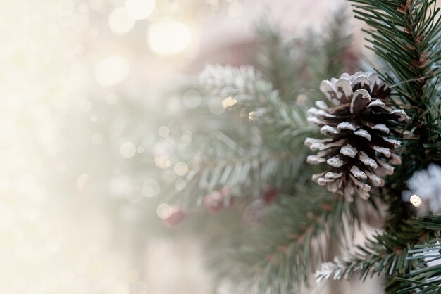 Hintergrund mit Weihnachtsbokeh-Effekt mit Tannenzweigen, Zapfen und Platz für Inschriften