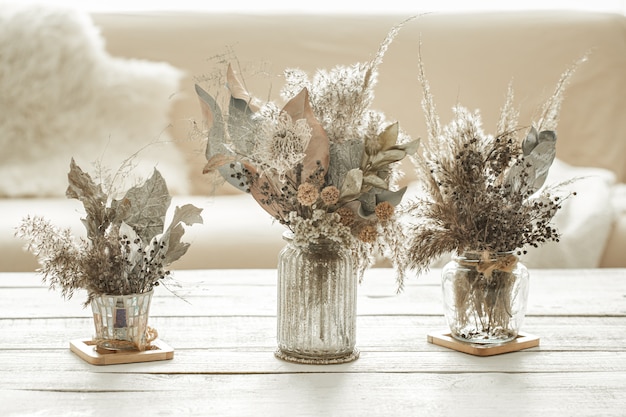 Hintergrundzusammensetzung mit vielen verschiedenen getrockneten Blumen in Vasen