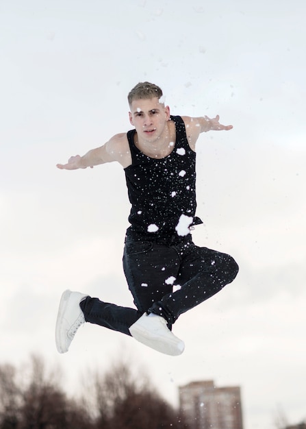Hip Hop Tänzer posiert mit Schnee draußen beim Tanzen