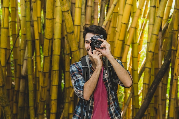 Kostenloses Foto hipster, der foto im bambuswald nimmt