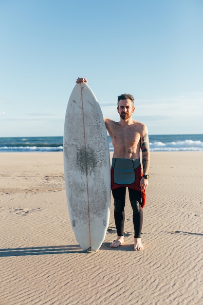 Hipster trendiger Surfer am Strand mit Surfbrett