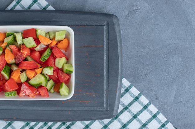 Hirtensalat gemischt mit Karottenscheiben auf einer Marineplatte auf Marmorhintergrund.