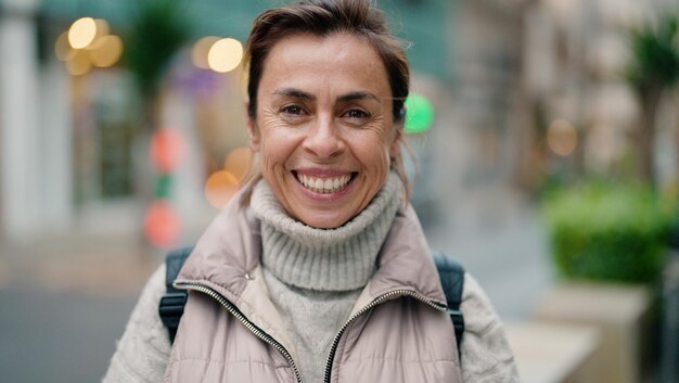 Hispanische Frau mittleren Alters lächelt selbstbewusst auf der Straße