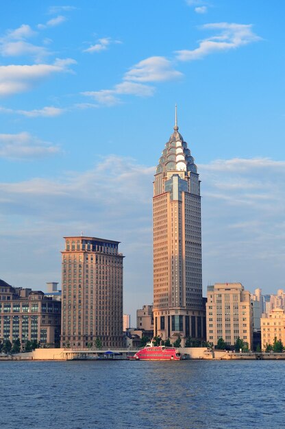 Historische und städtische Gebäude Shanghais über Huangpu-Fluss morgens mit blauem Himmel.